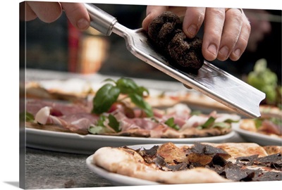 Close-up of chef rasping truffle over pizza