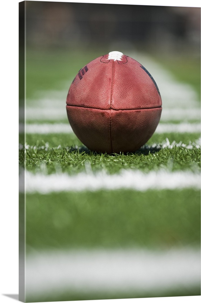 Close up of football on yard line marker