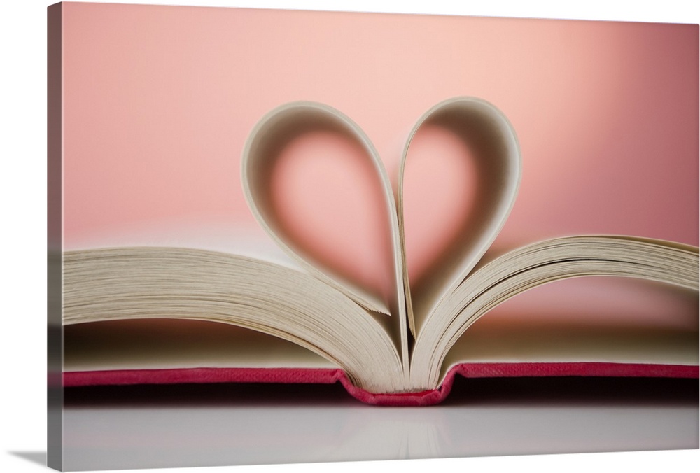 A picture taken of a book with its pages folded inward to form a heart shape.