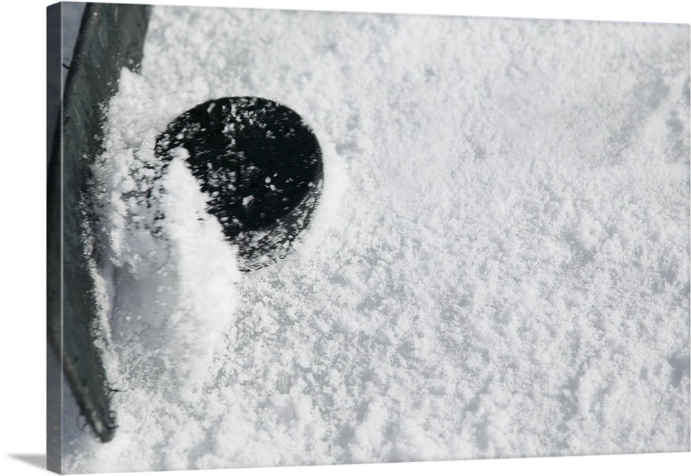 Close up of hockey stick and puck on ice