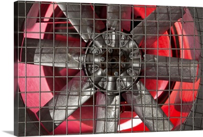 Close up of industrial fan behind metal grate