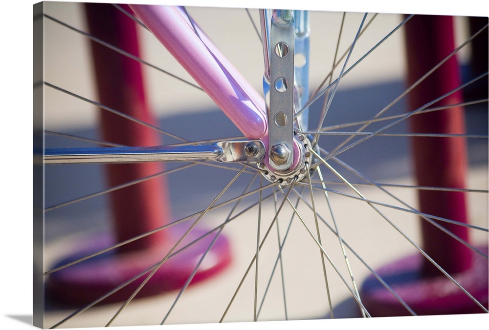 Close up of spokes on a pink bicycle,