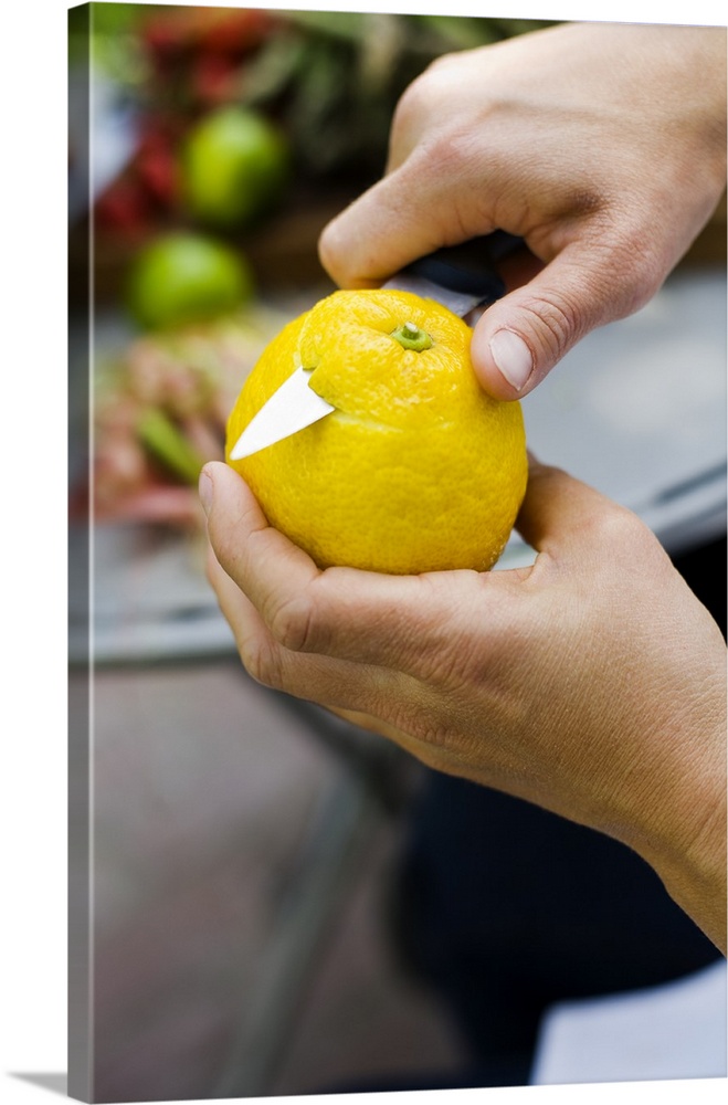 Close up of womans hands peeling lemon