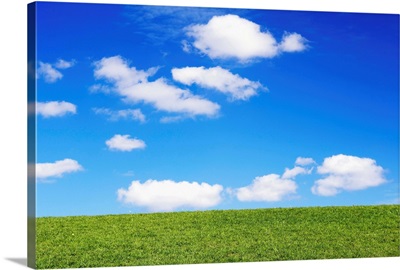 Clouds In Blue Sky Over Green Grass