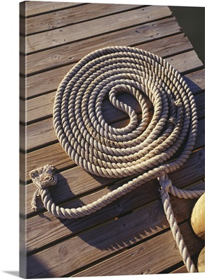 Coil of rope lying on wooden pier, elevated view