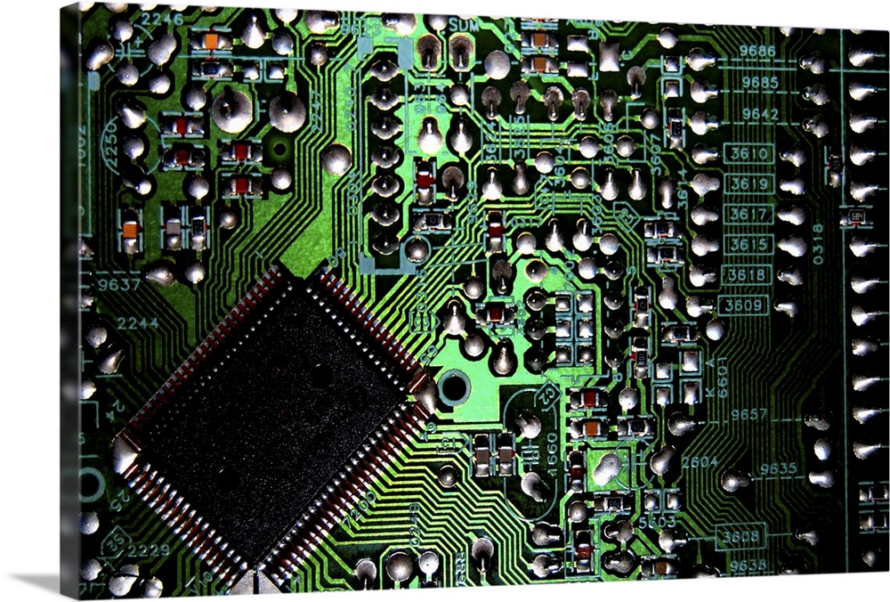 Macro image of a green, silver, and black circuit board from inside a computer.