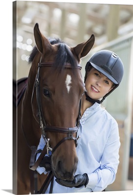 Confident equestrian and her horse in stable