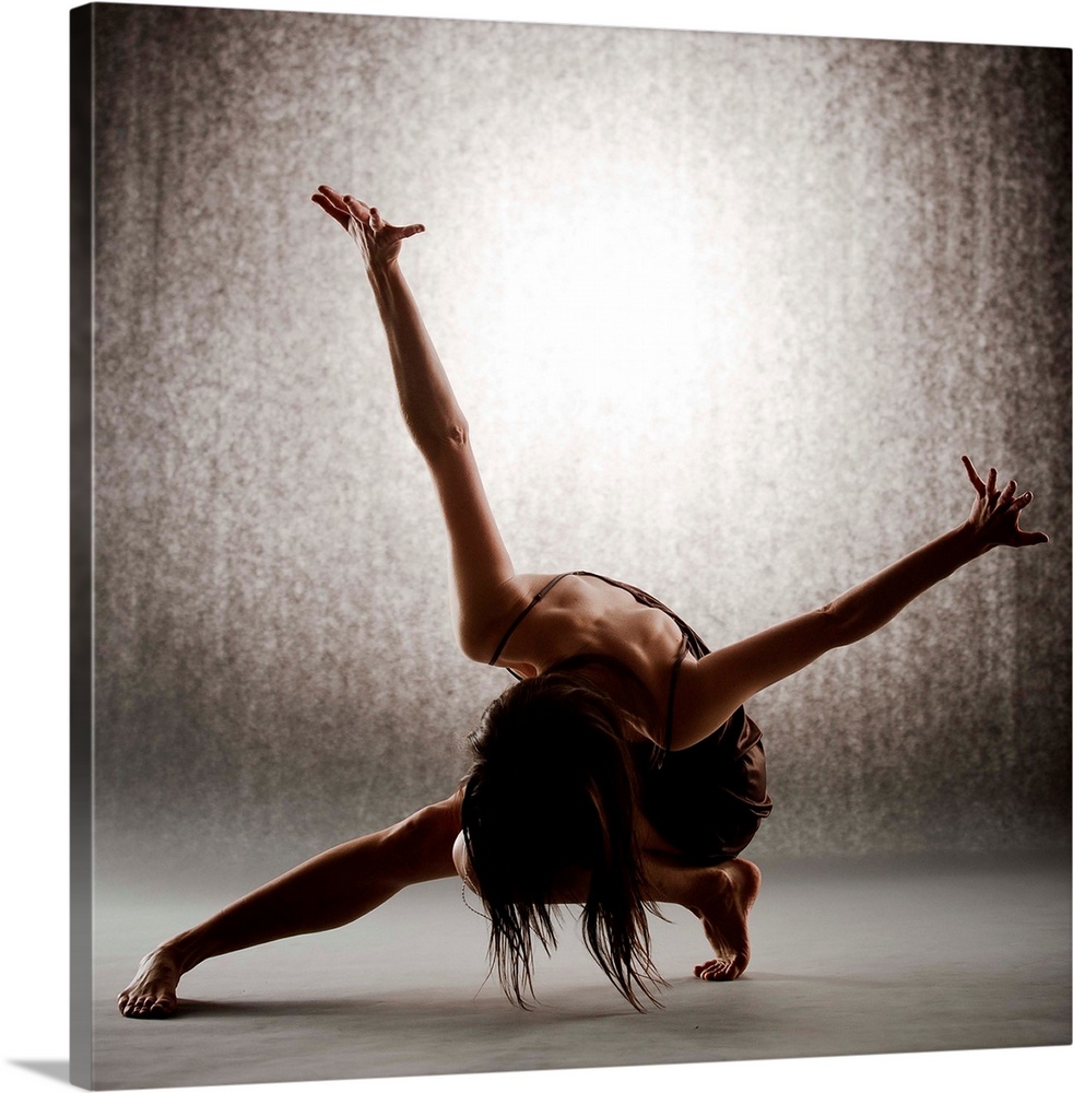 Dancer performing contemporary ballet on grey seamless backdrop wearing brown dress.