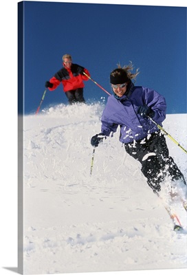 Couple downhill skiing