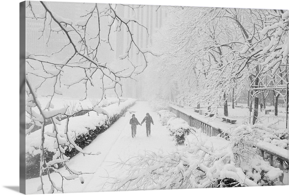 Winter Scene. New York: Snow-covered branches frame a couple as they walk on wet blanket of snow in midtown's Bryant Park....