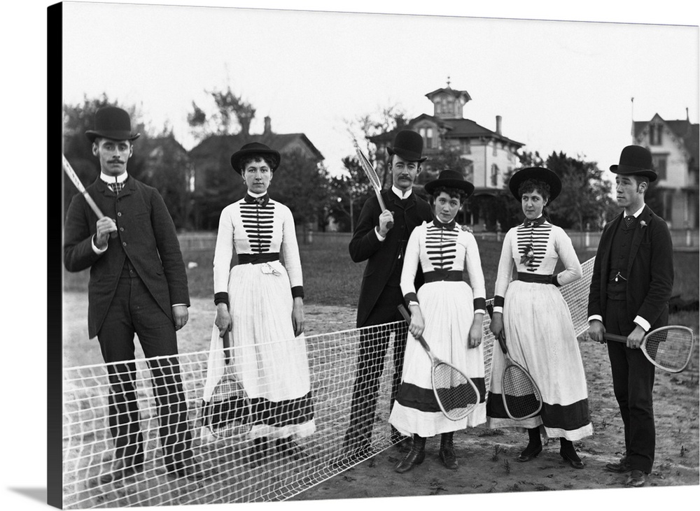 Three couples holding tennis rackets gather on a tennis court in a pretty Suburban town.