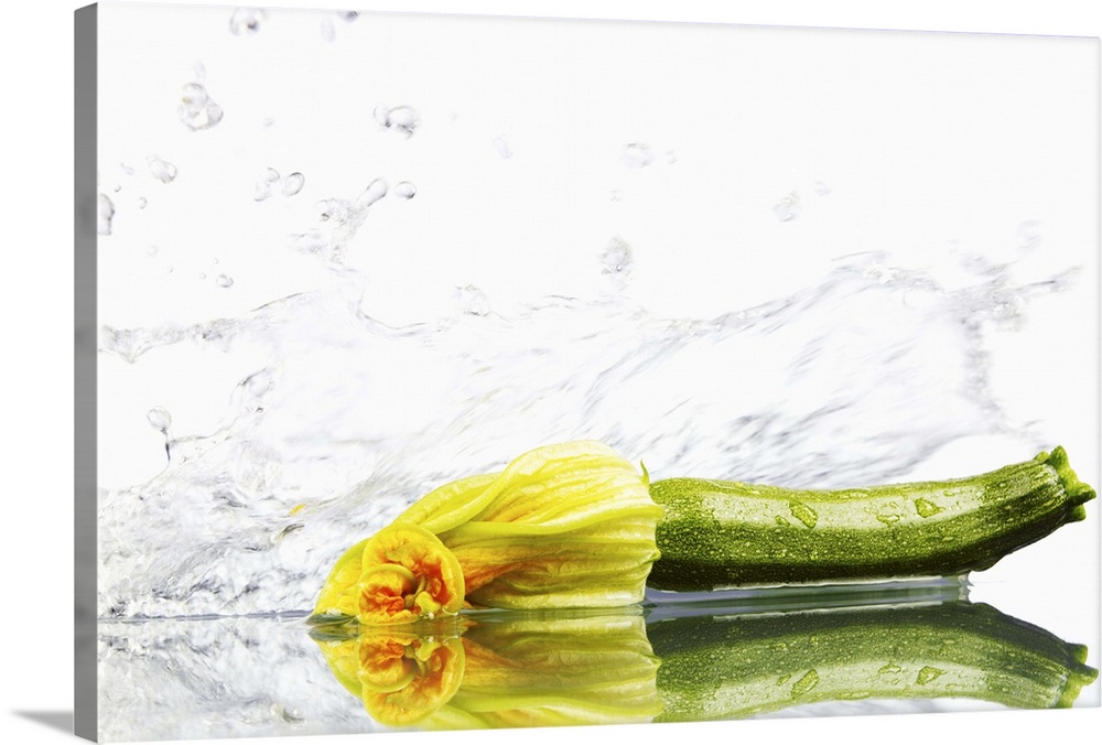 Courgette being washed against white background