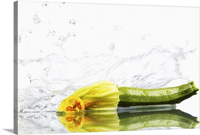 Courgette being washed against white background