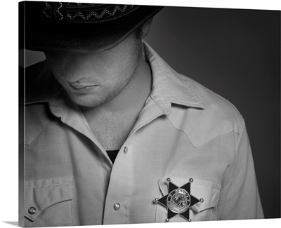 Cowboy Looking Down Under Hat With Sheriff's Badge On Shirt