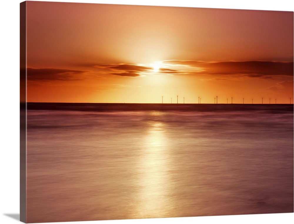 Crosby beach,golden sunset with windfarm turbines and long exposure sea.