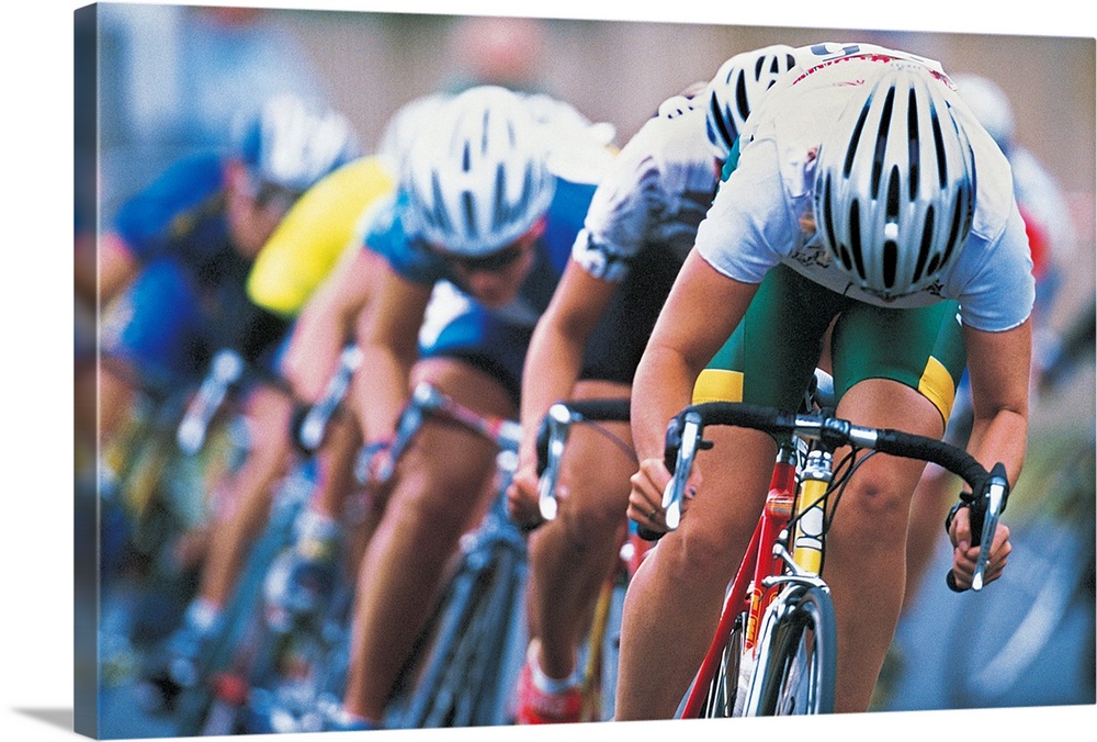 Photograph of a several racers in a bicycle race hurrying towards the finish line, with their heads down, pedaling hard.