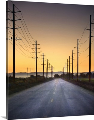 Desert road and power lines at sunset in California desert.