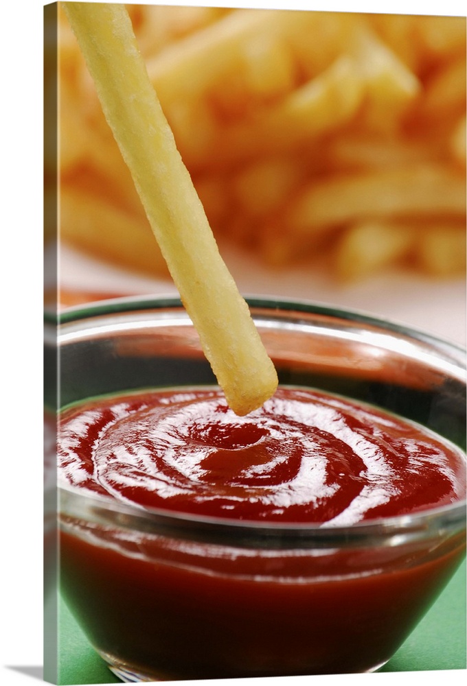 Dipping French fries in ketchup, close up