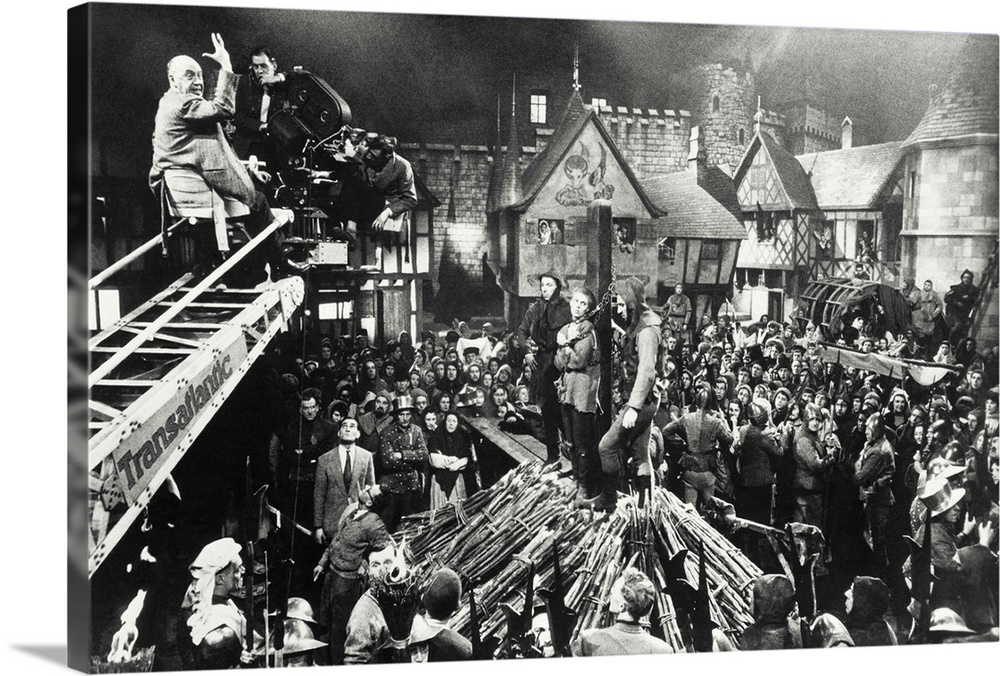 Producer-Director Otto Preminger, on camera boom, readies his crew and the crowd on a Rouen marketplace set, for the near-...