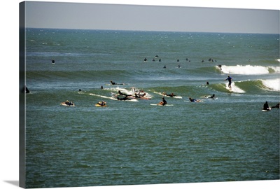 Distant view of a group of people surfing, Malibu, California, USA