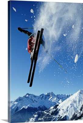 Downhill skier in mid-air, rear view