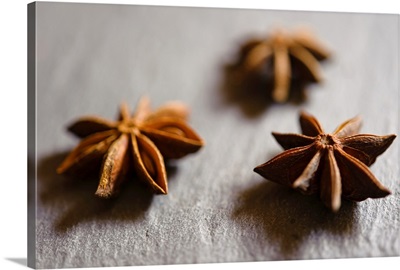 Dried Star anise pods displayed on a slate tray.