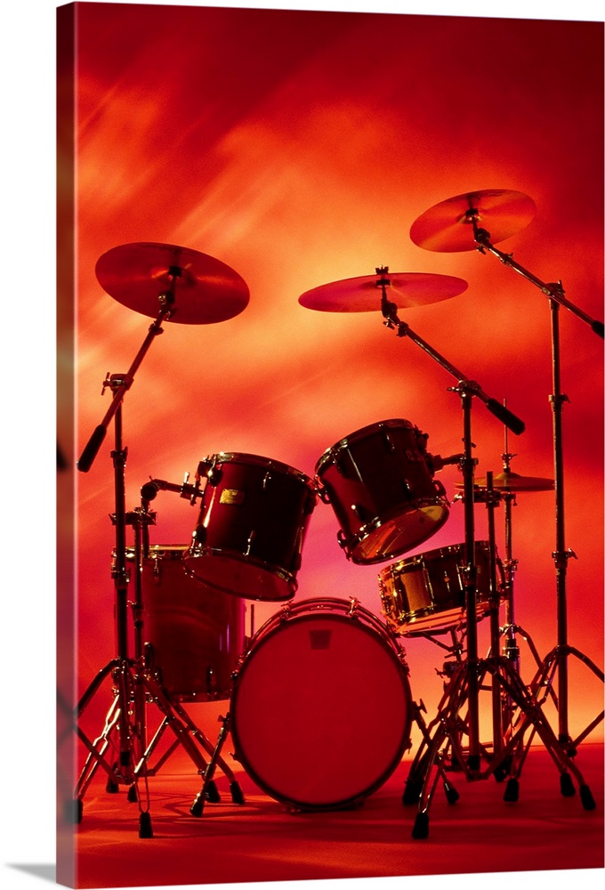 Large vertical photograph of a drum set with symbols, surrounded by warm, fiery lighting.