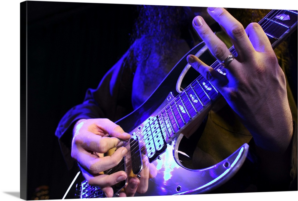 close up shot of an electric guitar as it is played up on stage