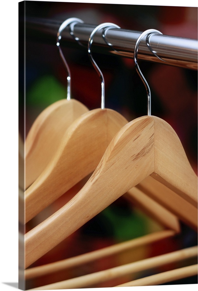 Few empty wooden clothes hangers on laundry rack.