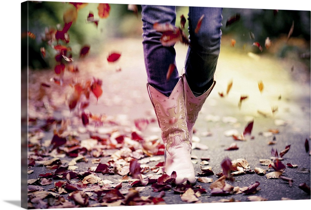 Cowgirl boots with autumn leaves falling.