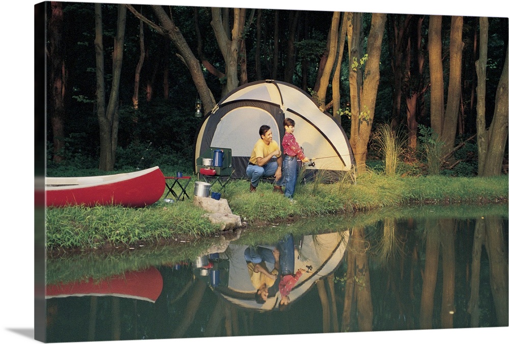 Father and son camping beside water