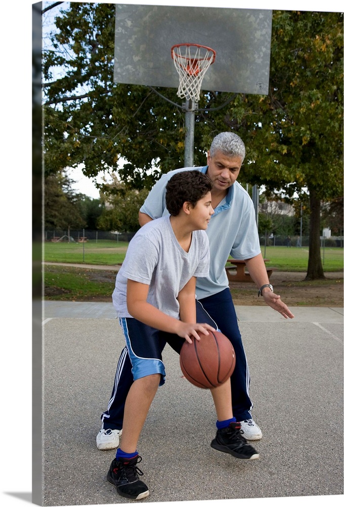 Hispanic father and son playing basketball