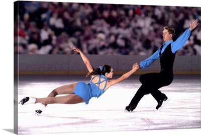 Figure skating pair performing in front of crowd