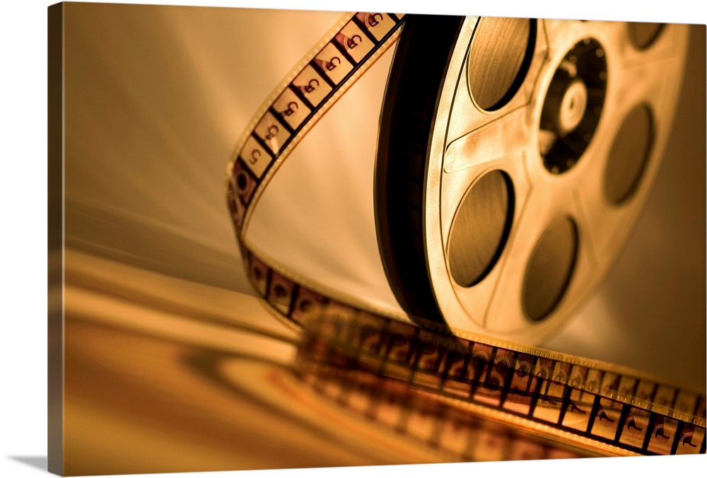 Landscape, large wall picture of a film reel sitting upright with unraveling film that curls toward the foreground.