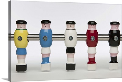 Five foosball figurines wearing different uniforms