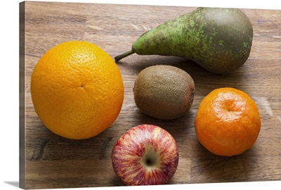 Five mixed pieces of fruit on a chopping board