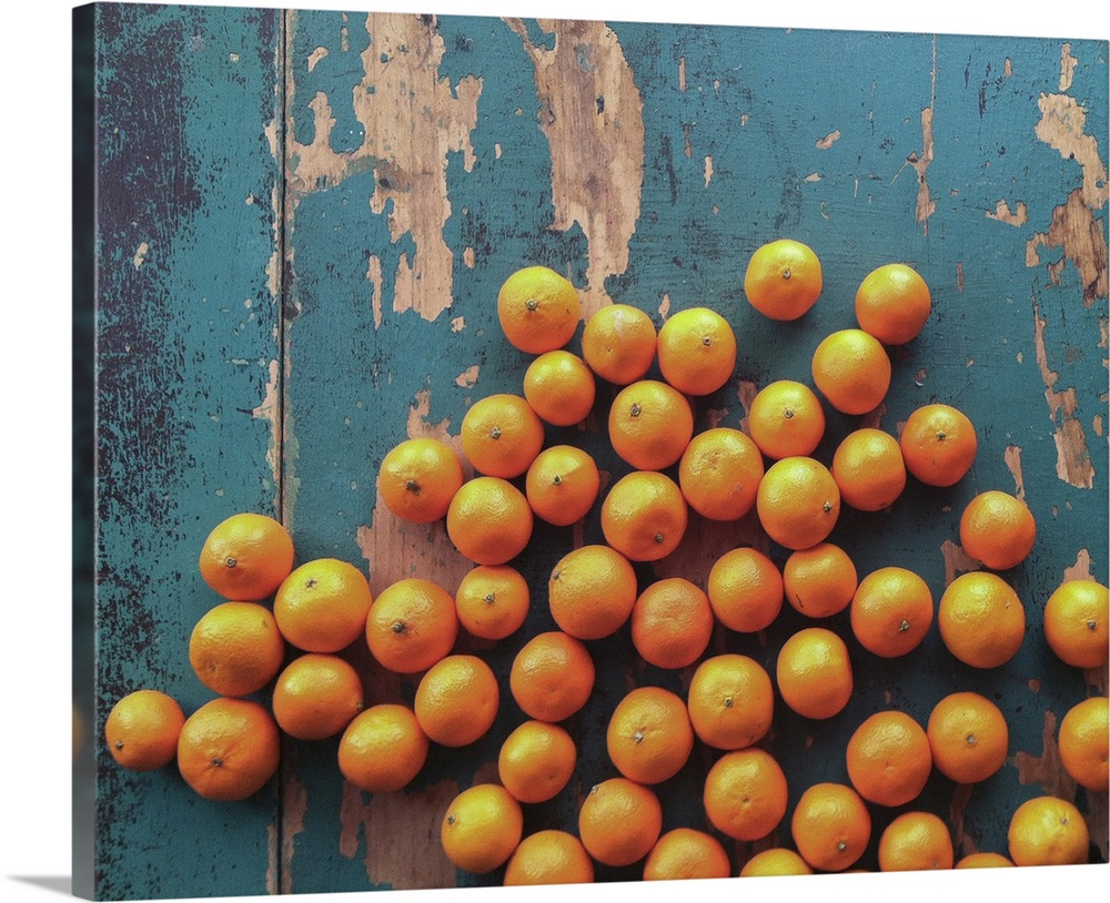Five pounds of clementine tangerines scattered on  wooden table with contrasting blue paint.