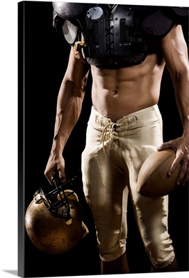 Football player with protective gear, football, and helmet