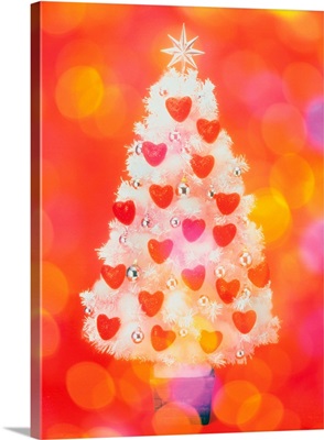 Frosted Christmas tree decorated with heart shaped ornaments, front view, composition