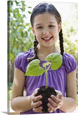 Girl holding soil and plant