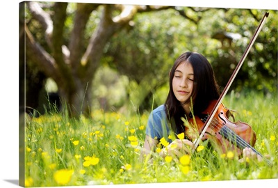 Girl in backyard, playing violin, eyes closed