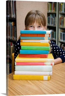 Girl looking over stack of books