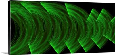 Green light trails creating an abstract wave pattern on a black background
