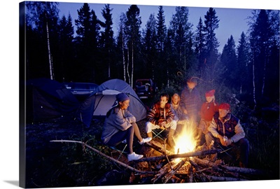 Group of people sitting by campfire