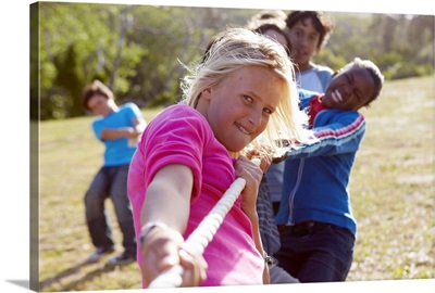 Group of teenagers, aged 13,  pulling together on a rope.