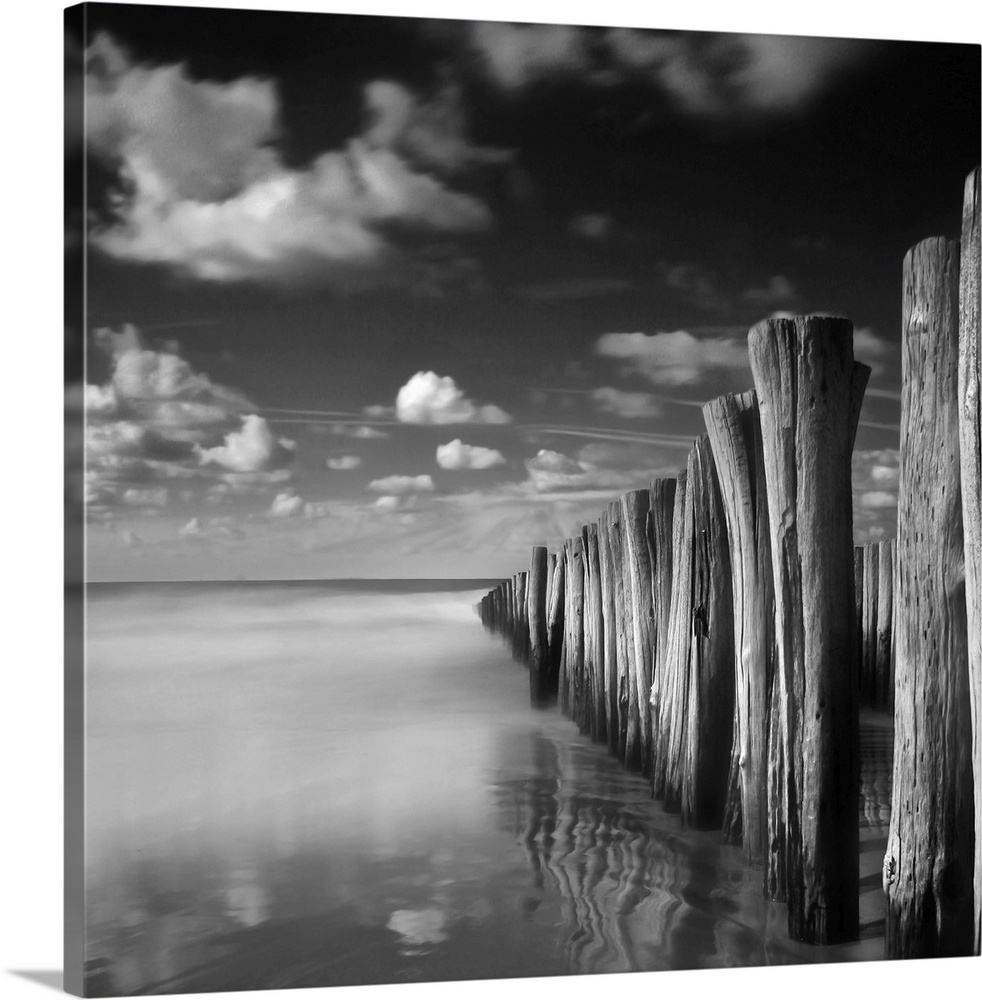 Groynes in sea in Domburg with heavy clouds.