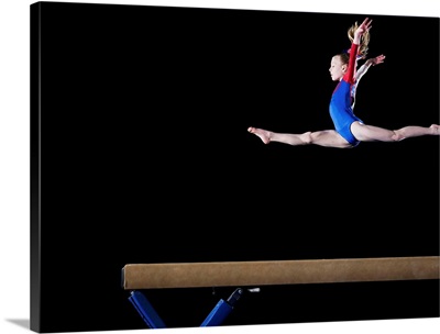 Gymnast leaping on balance beam