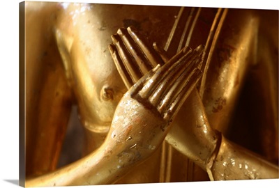 Hands of golden statue crossed over chest