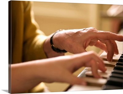 Hands playing piano together
