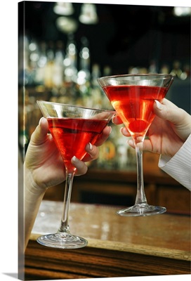 Hands toasting cosmopolitans